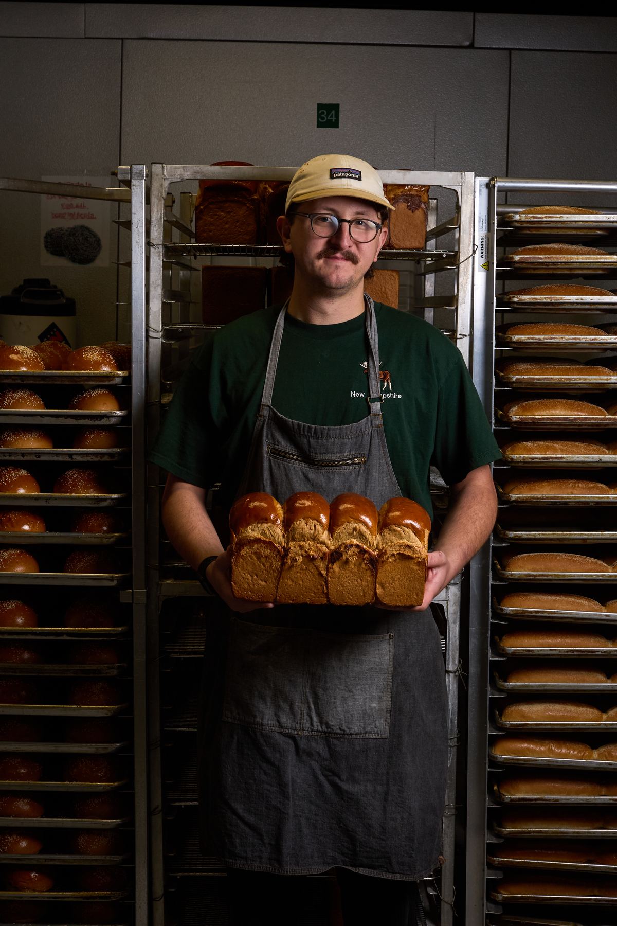 Baker holding a fresh loaf of milk bread in the bakery