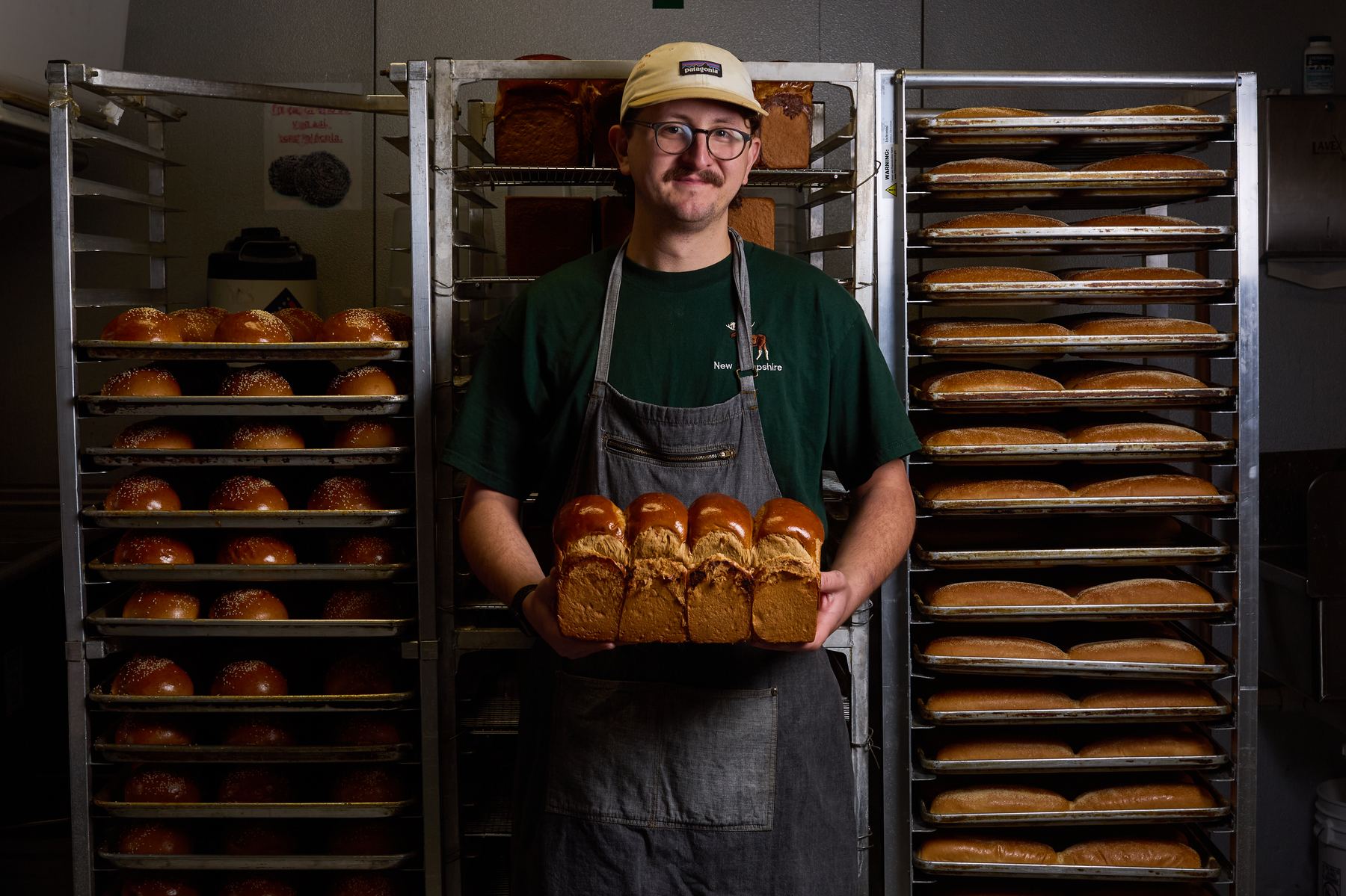 Baker holding a sliced peaked milk bread loaf