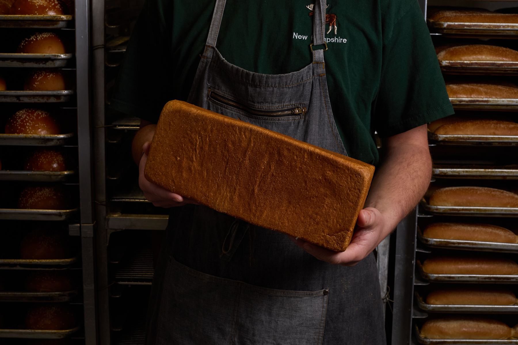 Baker holding a milk bread loaf