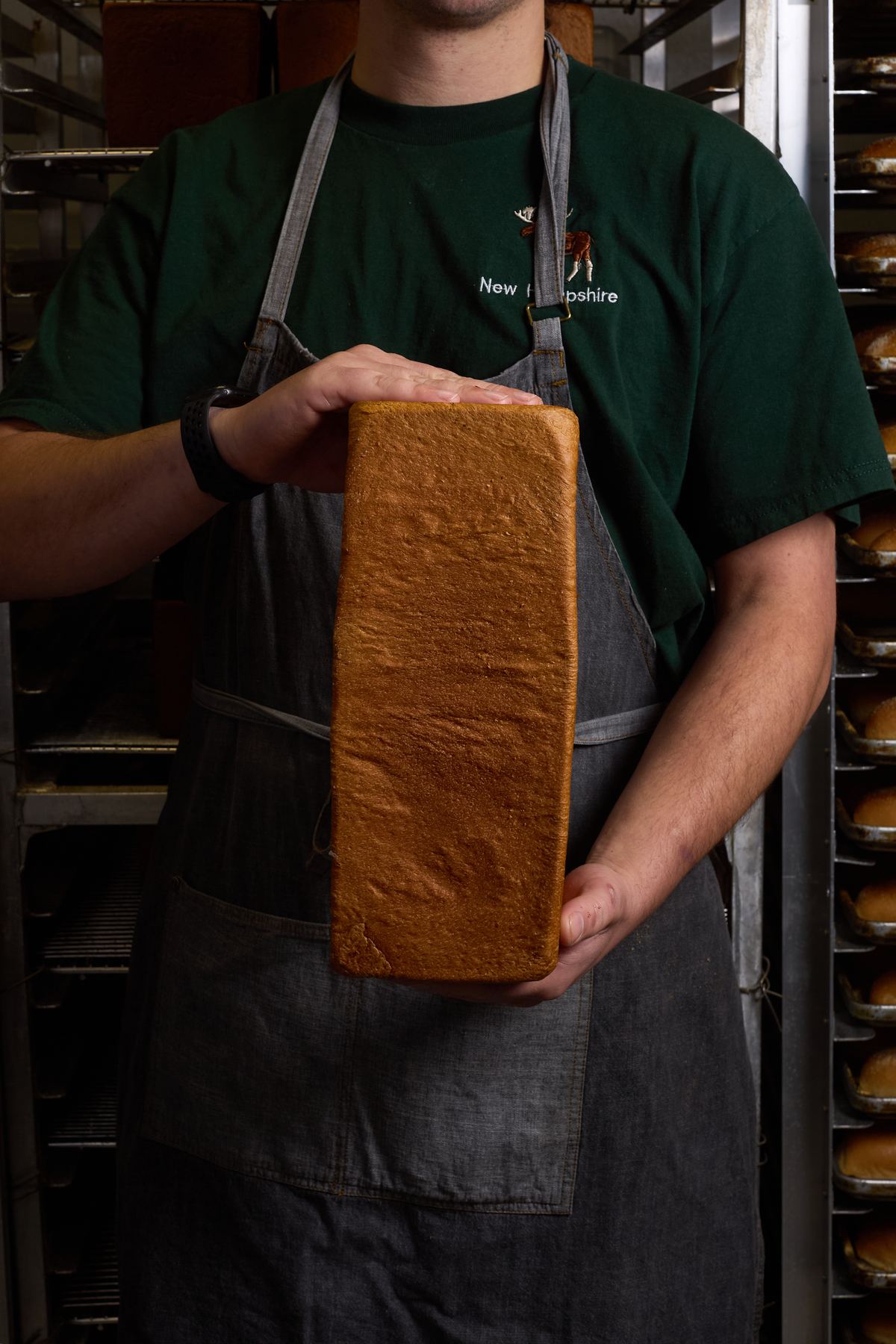 Baker holding a milk bread loaf